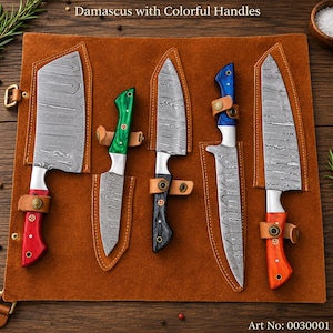May include: A set of five Damascus steel knives with colourful handles, including red, green, black, blue, and orange, arranged on a brown leather roll. The knives feature distinct wavy patterns on the blades and are secured with leather straps.