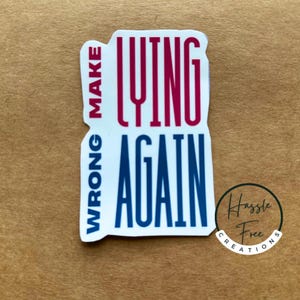 May include: A white sticker with the text "Make Lying Wrong Again" in red and blue lettering. The sticker has a black circle with the text "Hassle Free Creations" in white lettering.