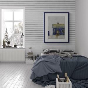 Può includere: Una scena di camera da letto accogliente con uno schema di colori blu e bianco. Un dipinto incorniciato di una casa blu è appeso sopra un letto con biancheria da letto blu. Un cestino di vimini bianco contiene bottiglie di vino.
