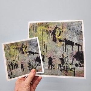 Può includere: Due stampe di una scena di strada astratta in nero, giallo e verde. Le stampe sono tenute in mano su uno sfondo azzurro. La stampa più grande misura circa 20 x 25 cm, e la più piccola misura circa 13 x 18 cm.