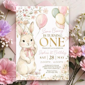 Puede incluir: Una invitación de cumpleaños con una ilustración en acuarela de un conejito con un gorro de fiesta y un globo rosa. El texto dice "Some Bunny is Turning One" con detalles del evento, rodeado de motivos florales.