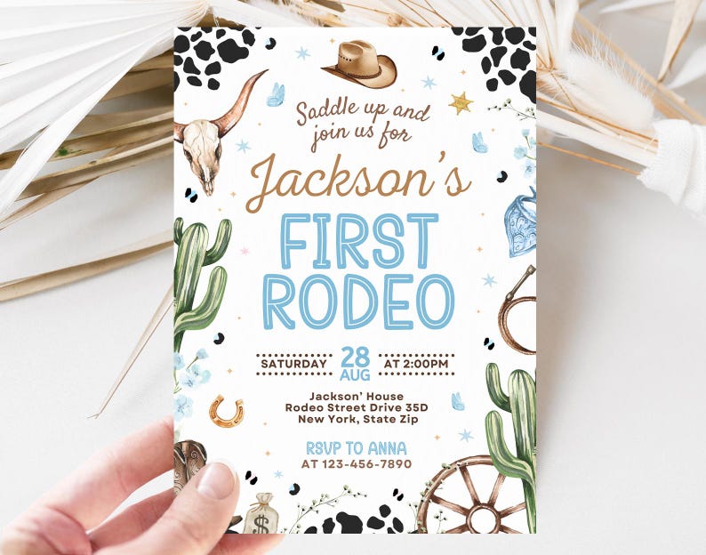 K&ouml;nnte beinhalten: Eine wei&szlig;e Einladungskarte mit Rodeo-Thema. Der Text lautet "Jackson's FIRST RODEO" in Blau und Braun. Die Karte zeigt Illustrationen eines Cowboyhuts, eines Kaktus, eines Hufeisens und eines Stiersch&auml;dels. Das Datum ist der 28. August.