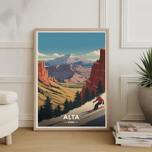May include: Framed art print featuring a stylized landscape of Alta, Utah. The artwork depicts a skier descending a snowy slope, with red rock formations and a mountain range in the background. The text "ALTA - UTAH" is at the bottom.