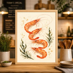 May include: A framed watercolour print showing four cooked prawns arranged vertically. The prawns are orange-red with fine antennae, set against a cream background with green seaweed and gold flecks.