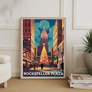 May include: A framed art print depicting Rockefeller Plaza during the Christmas season. The artwork features the Empire State Building, a large Christmas tree, and people walking on the street. The text "Rockefeller Plaza" is at the bottom.