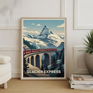 Może przedstawiać: Oprawiony wydruk przedstawiający czerwony pociąg na kamiennym moście na tle szwajcarskich Alp. Wydruk zawiera napis "Glacier Express - Switzerland" na dole. Styl vintage plakatu podróżniczego.