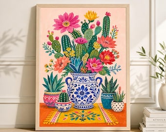 May include: A framed art print featuring a vibrant still life of cacti and flowers in a blue and white patterned vase. The arrangement includes various cacti, succulents, and colorful blooms, set against a peach background.