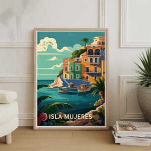 May include: A framed art print featuring a colorful illustration of Isla Mujeres, Mexico. The artwork depicts buildings in shades of orange, green, and yellow on a cliffside, with boats in the turquoise water below. The print includes the text "ISLA MUJERES MEXICO".