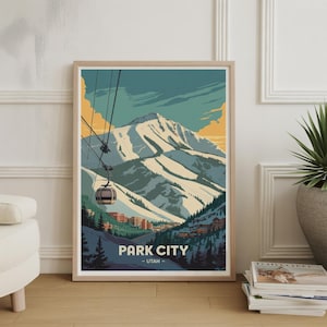 May include: A framed art print featuring a stylized mountain landscape with a ski lift. The artwork depicts a snow-covered mountain range under a blue and yellow sky. The text "PARK CITY - UTAH" is at the bottom.