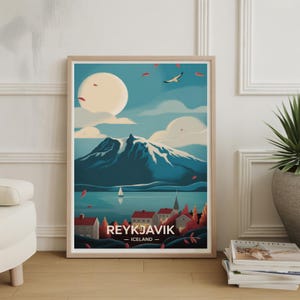 May include: A framed art print of Reykjavik, Iceland. The artwork depicts a mountain range, a lake with a sailboat, and a town with red-roofed buildings. The sky is a light blue with a large moon and a flying bird.