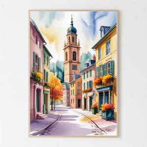 Op de afbeelding: Aquarel schilderij van een Europese stadsstraat. Gebouwen in roze, gele en groene tinten staan langs de straat, met een hoge klokkentoren op de achtergrond. Kleurrijke bloemen sieren balkons en bloembakken. De lucht is een mix van blauw en geel.