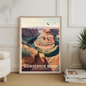May include: Framed art print of Horseshoe Bend in Arizona, United States. The artwork depicts the iconic canyon with a turquoise river winding through the red rock formations. The print is in a light wood frame.
