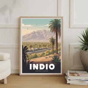 May include: Framed art print featuring a scenic landscape of Indio, California. The artwork showcases palm trees, a road, and mountains under a blue sky. The word "INDIO" is prominently displayed in white, with "UNITED STATES" below.