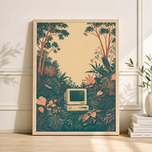 Pode incluir: Impressão artística emoldurada com um computador vintage em meio a uma folhagem exuberante e estilizada. A obra de arte apresenta um design de computador retrô com um monitor e base bege, cercado por folhas e árvores verdes e laranja, em um fundo creme.