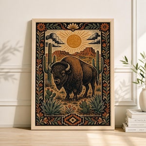 Puede incluir: Una impresión artística enmarcada que representa un bisonte en un paisaje desértico. La obra de arte muestra un bisonte marrón, cactus y un sol poniente. El marco tiene un borde decorativo con patrones florales y geométricos. La paleta de colores incluye tonos marrones, verdes y naranjas.