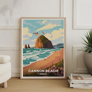 May include: A framed art print of Cannon Beach, Oregon. The artwork depicts a beach scene with a large rock formation, seagulls, and the text "Cannon Beach - Oregon". The color palette includes blues, oranges, and greens.