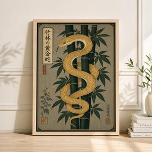 May include: A framed print depicting a golden snake entwined with bamboo. The artwork is in a traditional Japanese style, with Japanese text and a muted colour scheme of greens, golds, and tans. The snake's tongue is visible.