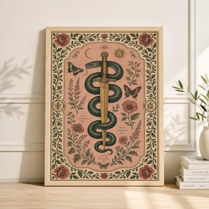 May include: Framed art print with a central design of a sword through a coiled snake. The artwork incorporates botanical elements, butterflies, and text. The color scheme is mainly muted pink, green, and gold, with a wooden frame.