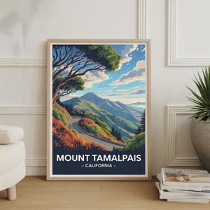 Op de afbeelding: Een ingelijste kunstafdruk met een landschap van Mount Tamalpais in Californië. De afbeelding toont een kronkelende weg door een berglandschap onder een blauwe lucht met wolken. De tekst "MOUNT TAMALPAIS - CALIFORNIA" staat onderaan.
