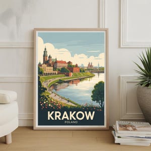 May include: Framed art print of Krakow, Poland, featuring a scenic river view with a castle and buildings. The artwork has a vintage travel poster style, with the city name in bold white letters on a dark blue background.