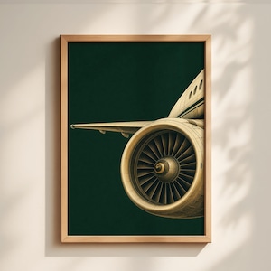 May include: A framed print featuring a detailed illustration of an airplane engine and wing against a dark green background. The engine is beige with dark blades, and the wing extends to the left. The artwork is in a wooden frame.