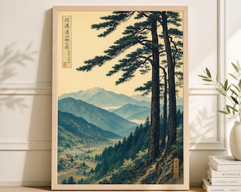 May include: A framed print of a Japanese landscape. The artwork shows tall pine trees, a valley with a village, and mountains in shades of blue and green. The print has Japanese text in the corners. The frame is made of light-colored wood.