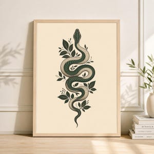 Könnte beinhalten: Gerahmter Kunstdruck mit einer stilisierten Illustration einer Schlange, die sich inmitten dunkelgrüner Blätter und kleiner weißer Blüten windet. Die Schlange ist hauptsächlich grau mit dunkelgrünen Akzenten. Der Hintergrund ist hellbeige.