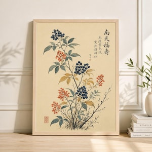 以下が含まれることがあります： フレームに入った植物画。青と赤のベリー、緑の葉、アジアの文字で描かれた植物の詳細なイラスト。 作品はクリーム色の背景に設定されています。