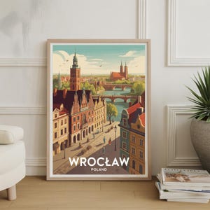 May include: Framed art print of Wrocław, Poland. The artwork depicts a colorful cityscape with buildings, bridges, and a river. The print has a light wooden frame and the word "WROCŁAW" is printed at the bottom.
