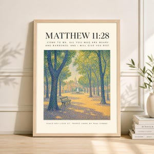 Pode incluir: Uma impressão artística emoldurada com uma paisagem pontilhista de um parque com árvores, um banco e uma fonte. O texto "MATEUS 11:28" e uma citação estão no topo. A parte inferior diz "PLACE DES LICES ST. TROPEZ (1893) BY PAUL SIGNAC."