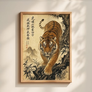 May include: Framed art print featuring a detailed painting of a tiger with orange and black stripes, walking down a tree branch. The artwork has Chinese calligraphy and a mountain landscape background. The frame is made of light brown wood.