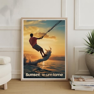 May include: Framed art print depicting a watersports scene at sunset. A person is wakeboarding on a wave, silhouetted against a vibrant orange and yellow sky. The text "Sunset in Miami" is at the bottom.