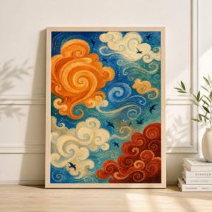 May include: A framed art print depicting a colourful, stylised sky scene. The artwork features swirling clouds in shades of orange, white, and red against a blue backdrop. Small black birds are scattered throughout the scene.