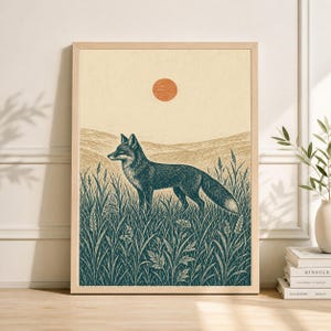 May include: A framed art print featuring a detailed illustration of a fox standing in tall grass. The artwork is in shades of teal and beige, with a warm orange sun in the background. The print is displayed in a light-colored wooden frame.
