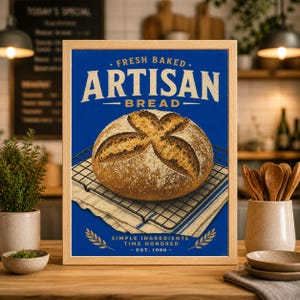 Puede incluir: Un cartel enmarcado con una hogaza de pan artesanal. La imagen tiene un fondo azul con las palabras "Fresh Baked Artisan Bread" en blanco. El pan está sobre una rejilla de enfriamiento sobre un paño a rayas azules y blancas. El texto "Simple Ingredients Time Honored - Est. 1986" está en la parte inferior.