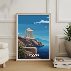May include: A framed art print featuring a coastal landscape of Rhodes, Greece. The artwork depicts a classical temple on a cliff overlooking the blue sea, with seagulls in the sky. The print has a light wood frame and the word "RHODES" is printed at the bottom.