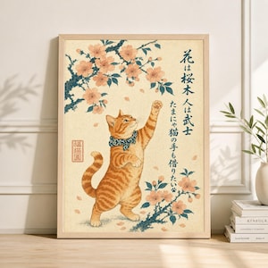 May include: A framed print featuring a stylized orange tabby cat reaching towards a flowering cherry blossom branch. The artwork has Japanese text and a decorative border. The cat wears a blue patterned collar.
