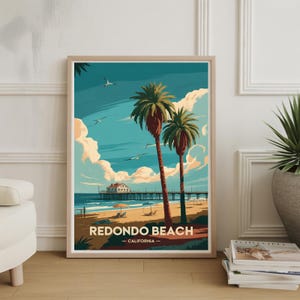 May include: A framed art print of Redondo Beach, California. The artwork depicts a beach scene with palm trees, a pier, and seagulls against a blue sky with clouds. The text "Redondo Beach - California" is at the bottom.