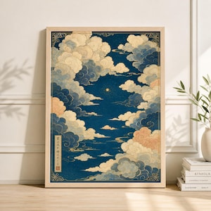 May include: A framed art print featuring a stylized depiction of clouds in shades of blue, cream, and peach against a dark blue background. The artwork has a Japanese aesthetic, with gold accents and text in the lower left corner. The print is in a light wood frame.