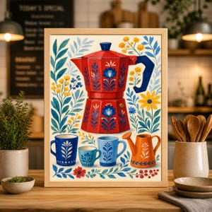 May include: A framed art print featuring a red coffee maker with blue floral designs, accompanied by blue mugs and an orange watering can. The artwork is surrounded by colorful floral elements, creating a vibrant kitchen-themed scene.