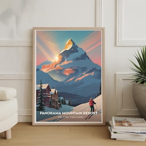 May include: Framed art print featuring a mountain scene with a skier and the text "Panorama Mountain Resort, British Coalumba." The artwork depicts a snow-covered mountain with a sunset in the background. Red and brown buildings are visible at the base of the mountain.