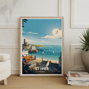 May include: A framed art print of St Ives, Cornwall, showing a coastal scene. The artwork depicts a sunny day with a blue sky, white clouds, and sailboats on the turquoise water. The print includes the text "ST IVES - CORNWALL".