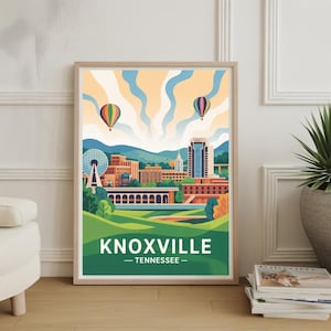 Puede incluir: Una impresión artística enmarcada que presenta una ilustración estilizada de Knoxville, Tennessee. La obra de arte muestra el horizonte de la ciudad, espacios verdes y globos aerostáticos contra un cielo azul y naranja. La palabra "KNOXVILLE" se muestra de forma destacada.