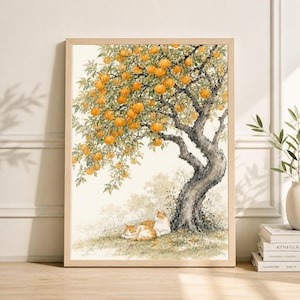 May include: A framed watercolor print depicts a tree laden with orange fruit. Two cats rest in the shade of the tree. The artwork has a natural wood frame and is displayed on a white wall.