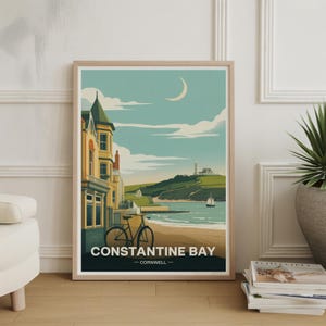 May include: A framed art print featuring a coastal scene with a bicycle on a beach. The artwork depicts a lighthouse, buildings, and the text "CONSTANTINE BAY - CORNWALL" in a vintage travel poster style. The color palette includes shades of blue, green, and beige.