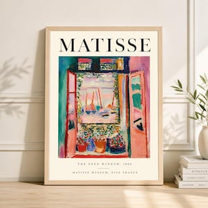May include: A framed print of Matisse's "The Open Window, 1905." The artwork depicts a vibrant scene of a window overlooking a harbor, with boats and colorful flowers. The print includes the artist's name and museum details.