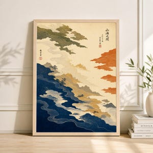 May include: Framed art print featuring a stylized landscape with Japanese text. The artwork depicts layered clouds and mountains in shades of blue, green, orange, and beige. The print is in a light wood frame, suitable for home decor.