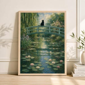 Op de afbeelding: Ingelijste kunstdruk van een serene vijver met een groene brug en een zwarte kat. Het water is gevuld met waterlelies en roze en witte bloemen, omringd door weelderig groen.