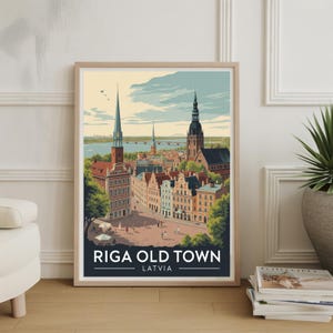 May include: Framed art print of Riga Old Town, Latvia. The artwork depicts a colorful cityscape with buildings, spires, and a river. The print is in a wooden frame and is displayed on a wall. The print has the text "RIGA OLD TOWN LATVIA".