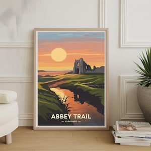 Könnte beinhalten: Gerahmter Kunstdruck mit einer Landschaft mit Fluss, grünen Hügeln und einem Sonnenuntergang in Orange- und Gelbtönen. Der Druck enthält den Text "Abbey Trail - Yorkshire". Das Kunstwerk befindet sich in einem Holzrahmen.